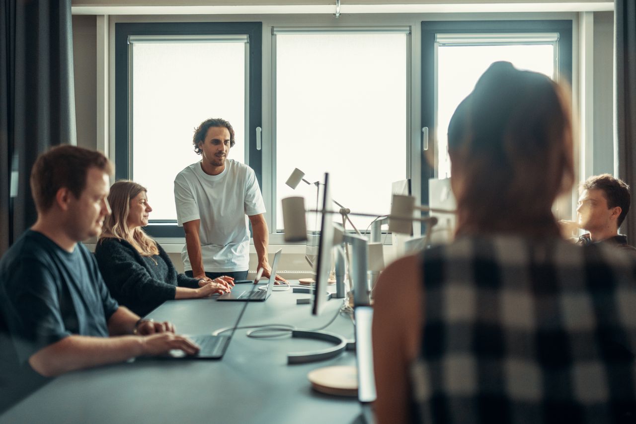 Une équipe variée en pleine discussion lors d’une réunion collaborative au bureau.