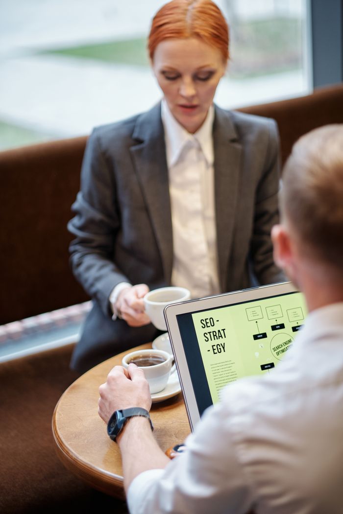 Réunion professionnelle dans un café avec un ordinateur portable présentant une stratégie SEO. Idéal pour les concepts d’entreprise.